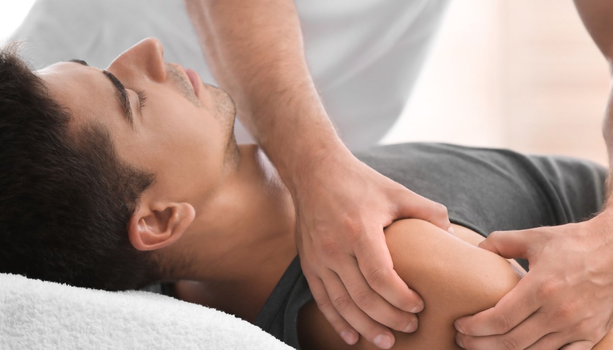 young man receiving massage in salon, closeup